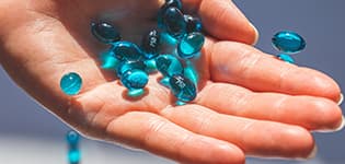 Blue pills in hand illustrates PlusChem's expertise in the Pharmaceutical industry